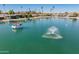 Beautiful view of the lake with a red and white pontoon boat and water fountain at 10116 W Bolivar Dr, Sun City, AZ 85351
