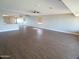 Spacious living room with wood look floors, ceiling fan, and mirrors on the walls at 10116 W Bolivar Dr, Sun City, AZ 85351