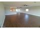 Bright living room with wood-look floors, ceiling fan, window, and a mirrored wall at 10116 W Bolivar Dr, Sun City, AZ 85351