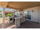Outdoor kitchen with built-in grill and bar area, perfect for entertaining and enjoying outdoor meals at 10116 W Bolivar Dr, Sun City, AZ 85351