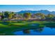 Picturesque golf course view with lush green fairways, sand traps, water features, and mountain backdrop at sunrise at 10125 N 78Th Pl, Scottsdale, AZ 85258