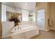 Luxurious bathtub in bathroom featuring glass block window and a separate shower at 10125 N 78Th Pl, Scottsdale, AZ 85258