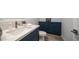 Stylish bathroom with navy blue cabinets, light countertops and wood style floors at 11673 N 136Th St # 1005, Scottsdale, AZ 85259