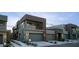 Contemporary townhome with a balcony, two-car garage, stone accents, and desert landscaping at 11673 N 136Th St # 1005, Scottsdale, AZ 85259