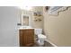 Cozy powder room featuring a vanity with oak-toned cabinets and decorative wall shelving at 1222 W Baseline Rd # 114, Tempe, AZ 85283