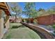 Serene backyard featuring lush lawn, a low brick wall, mature landscaping, and blooming flowers at 13601 S 37Th St, Phoenix, AZ 85044