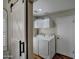 Functional laundry room with a sliding barn door, modern washer/dryer, and practical overhead storage at 13601 S 37Th St, Phoenix, AZ 85044