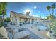 Inviting backyard setting featuring lounge chairs, lush desert landscape, a pool with rocks and a covered patio at 1414 E Amberwood Dr, Phoenix, AZ 85048