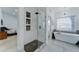 Bright bathroom showcasing a modern soaking tub and a glass-enclosed shower at 1414 E Amberwood Dr, Phoenix, AZ 85048