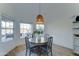 Bright breakfast nook features a round wooden table with seating for four under a wicker light fixture at 1414 E Amberwood Dr, Phoenix, AZ 85048