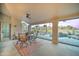 Charming covered patio with comfortable seating, a ceiling fan and a view of the landscaped backyard and pool at 1414 E Amberwood Dr, Phoenix, AZ 85048