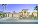 Attractive desert home showcasing an arched entryway, desert landscaping, and a three-car garage at 1414 E Amberwood Dr, Phoenix, AZ 85048