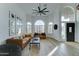 Bright living space with wood-look floors, a ceiling fan, large windows, and a view of the front door at 1414 E Amberwood Dr, Phoenix, AZ 85048