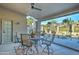 Covered outdoor patio with a ceiling fan and seating area overlooking the landscape at 1414 E Amberwood Dr, Phoenix, AZ 85048