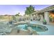 Inviting backyard featuring a custom pool with rock accents and a covered patio with a swing and lounge chairs at 1414 E Amberwood Dr, Phoenix, AZ 85048