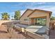 View of the backyard with a large concrete patio and desert landscaping featuring palm trees at 14720 W Edgemont Ave, Goodyear, AZ 85395