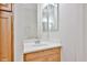 Bright bathroom features a single sink vanity with light wood cabinets and a decorative mirror at 14720 W Edgemont Ave, Goodyear, AZ 85395