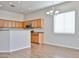 Bright kitchen area with a partial wall, modern chandelier, and wood-look flooring at 14720 W Edgemont Ave, Goodyear, AZ 85395