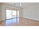 Open living area with wood-look flooring, sliding glass doors to a covered patio, and a ceiling fan at 14720 W Edgemont Ave, Goodyear, AZ 85395