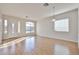 Sun-filled living room with wood-look floors, white walls, and large windows near front entrance at 14720 W Edgemont Ave, Goodyear, AZ 85395