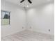 A bright bedroom with neutral walls, marble-look tile flooring, and a ceiling fan at 1625 S 113Th Ave, Avondale, AZ 85323