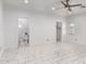 Bright bedroom with white walls, a modern ceiling fan, an attached bathroom, and a walk in closet at 1625 S 113Th Ave, Avondale, AZ 85323