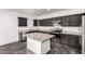 Modern kitchen featuring dark cabinets, gray granite countertops, an island, and stainless steel appliances at 1625 S 113Th Ave, Avondale, AZ 85323