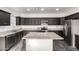 Beautiful kitchen featuring dark cabinets, granite countertops, an island, and stainless steel appliances at 1625 S 113Th Ave, Avondale, AZ 85323