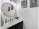 Stylish powder room featuring a gold faucet, round mirror, and white countertop at 16825 S 12Th Way, Phoenix, AZ 85048