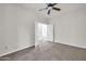 This bedroom features neutral carpet, ceiling fan, and an attached bathroom at 17388 W Elaine Dr, Goodyear, AZ 85338