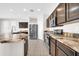 Open kitchen with stainless steel appliances, island, granite counters, and tile flooring at 17388 W Elaine Dr, Goodyear, AZ 85338