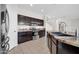 Modern kitchen with stainless steel appliances, island, tile floors and dark brown cabinets at 17388 W Elaine Dr, Goodyear, AZ 85338