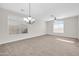 Bright living room featuring neutral carpet, a chandelier, and large windows at 17388 W Elaine Dr, Goodyear, AZ 85338
