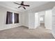 Neutral main bedroom featuring ceiling fan, carpet and ensuite bath at 17388 W Elaine Dr, Goodyear, AZ 85338
