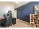 This bedroom features a blue accent wall, plush carpet, and a bookshelf filled with books at 17722 N 183Rd Ave, Surprise, AZ 85374