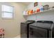 Efficient laundry room with modern washer and dryer, shelving, and natural light at 17722 N 183Rd Ave, Surprise, AZ 85374