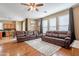 Spacious living room with hardwood floors, comfortable leather seating, and large windows at 17722 N 183Rd Ave, Surprise, AZ 85374