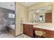 This bathroom has a built-in vanity, a tiled wall, and a soaking tub next to a window at 1807 E Medlock Dr, Phoenix, AZ 85016