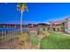 Beautiful backyard with a view of the lake, palm tree, pergola, and outdoor seating at 18207 W Hope Dr, Goodyear, AZ 85338