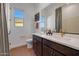 Bright bathroom featuring a double sink vanity, warm terra cotta flooring, and a window at 18429 W Mohave St, Goodyear, AZ 85338