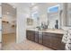 Modern bathroom with double vanity, a large mirror, stylish tile flooring, and a walk-in closet at 18429 W Mohave St, Goodyear, AZ 85338
