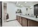 Modern bathroom featuring granite counters, dual sinks, wood cabinets, and a separate shower area at 19140 N 259Th Ave, Buckeye, AZ 85396