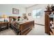 Cozy bedroom featuring a wooden bed frame, decorative pillows, and a side table with a lamp at 19140 N 259Th Ave, Buckeye, AZ 85396