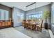 Bright dining room featuring a modern chandelier, a large window, and a stylish wooden dining table at 19140 N 259Th Ave, Buckeye, AZ 85396
