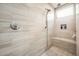 Detailed view of a shower with modern fixtures, stone-look tile, a shower bench, and built-in storage at 19140 N 259Th Ave, Buckeye, AZ 85396
