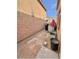 Narrow backyard including a red umbrella, furniture, and pots for plants at 2019 N 78Th Ave, Phoenix, AZ 85035