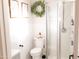 Bright bathroom featuring a glass shower, white wainscoting, decorative wreath, and modern fixtures at 2113 E Glencove St, Mesa, AZ 85213