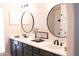Bathroom featuring dual sinks, black fixtures and two round mirrors at 2113 E Glencove St, Mesa, AZ 85213