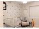Bedroom with a white crib, white glider, and triangle-patterned wallpaper at 2113 E Glencove St, Mesa, AZ 85213