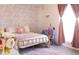 Bedroom featuring a bed with a pink throw blanket and pink floral wallpaper at 2113 E Glencove St, Mesa, AZ 85213